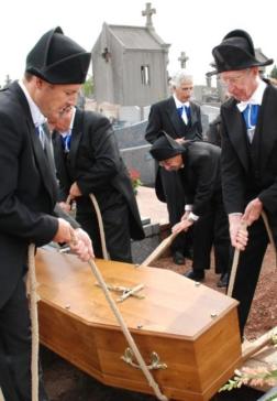 ﻿Les Charitables au nombre de quatre déposent le cercueil dans la tombe